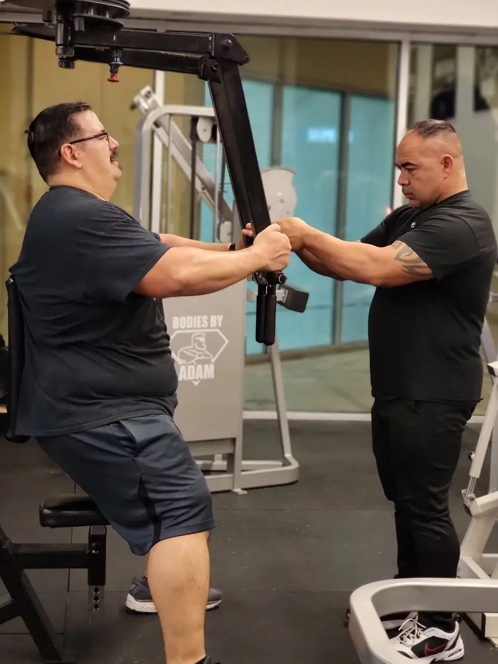 Coach guiding a client through a machine press